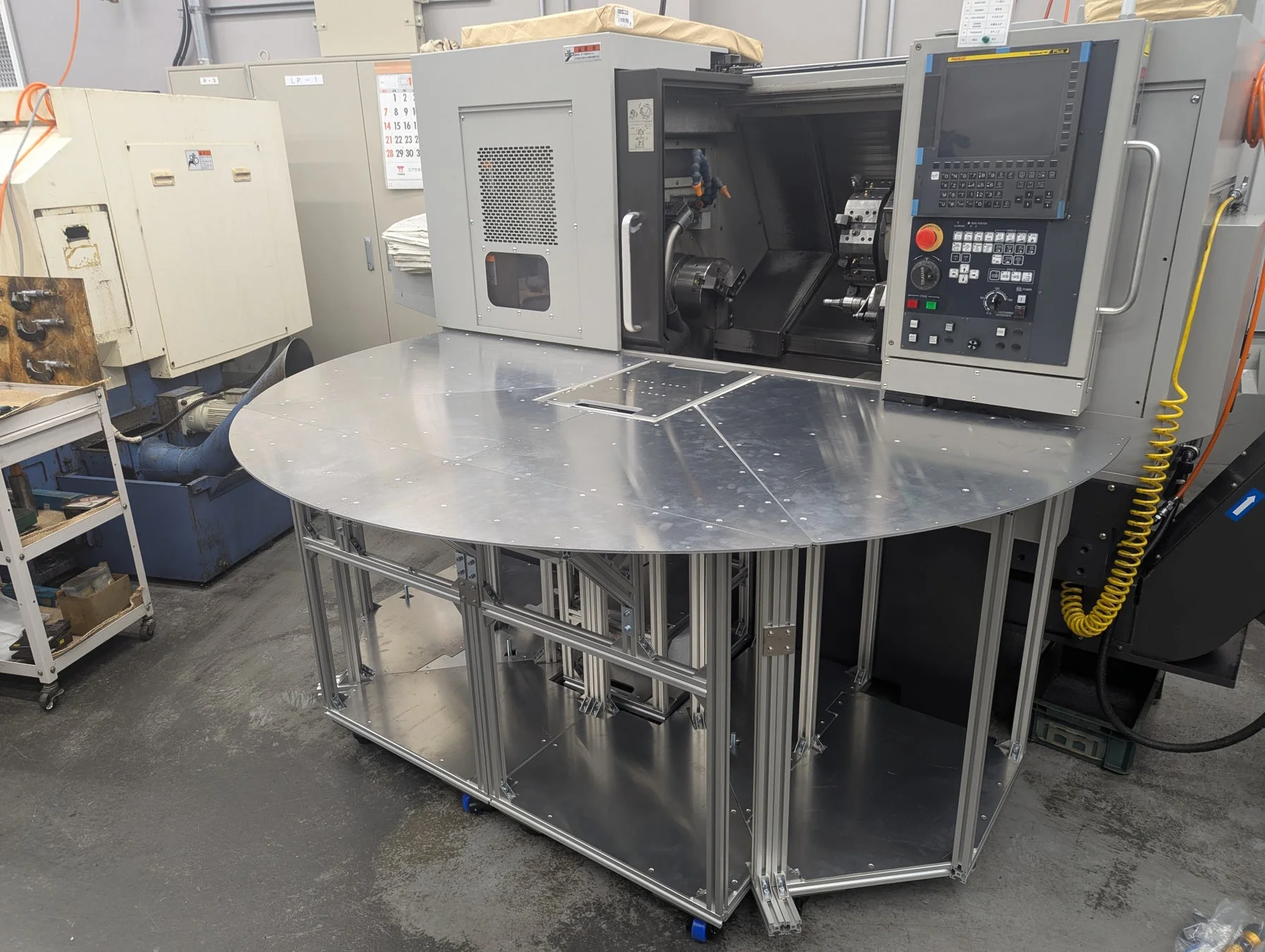 工場に設置されたCNC旋盤と作業テーブル