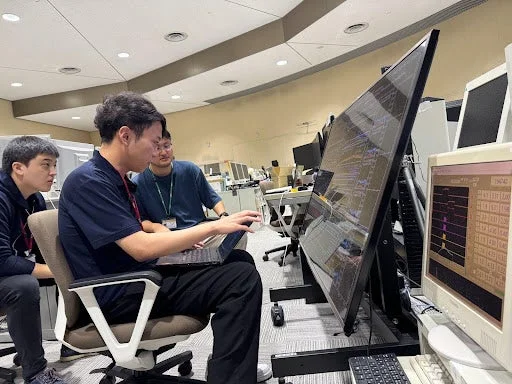 複数の男性がオフィス環境で協力して作業している様子