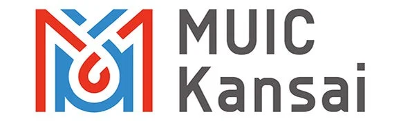 赤と青の線で構成された抽象的なロゴと「MUIC Kansai」という文字が並んだデザインです。