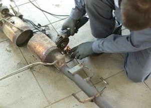 自動車の排気システムを修理する整備士