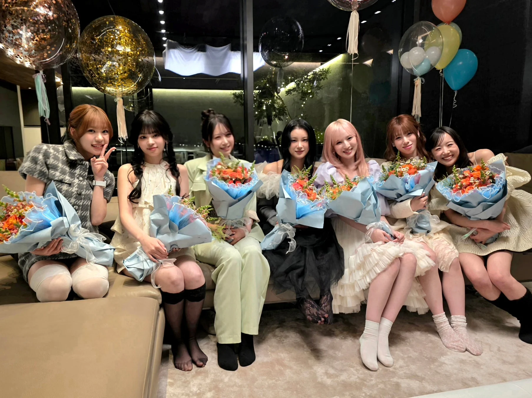 7人の女性が花束を持ち、笑顔でカメラにポーズをとっている集合写真