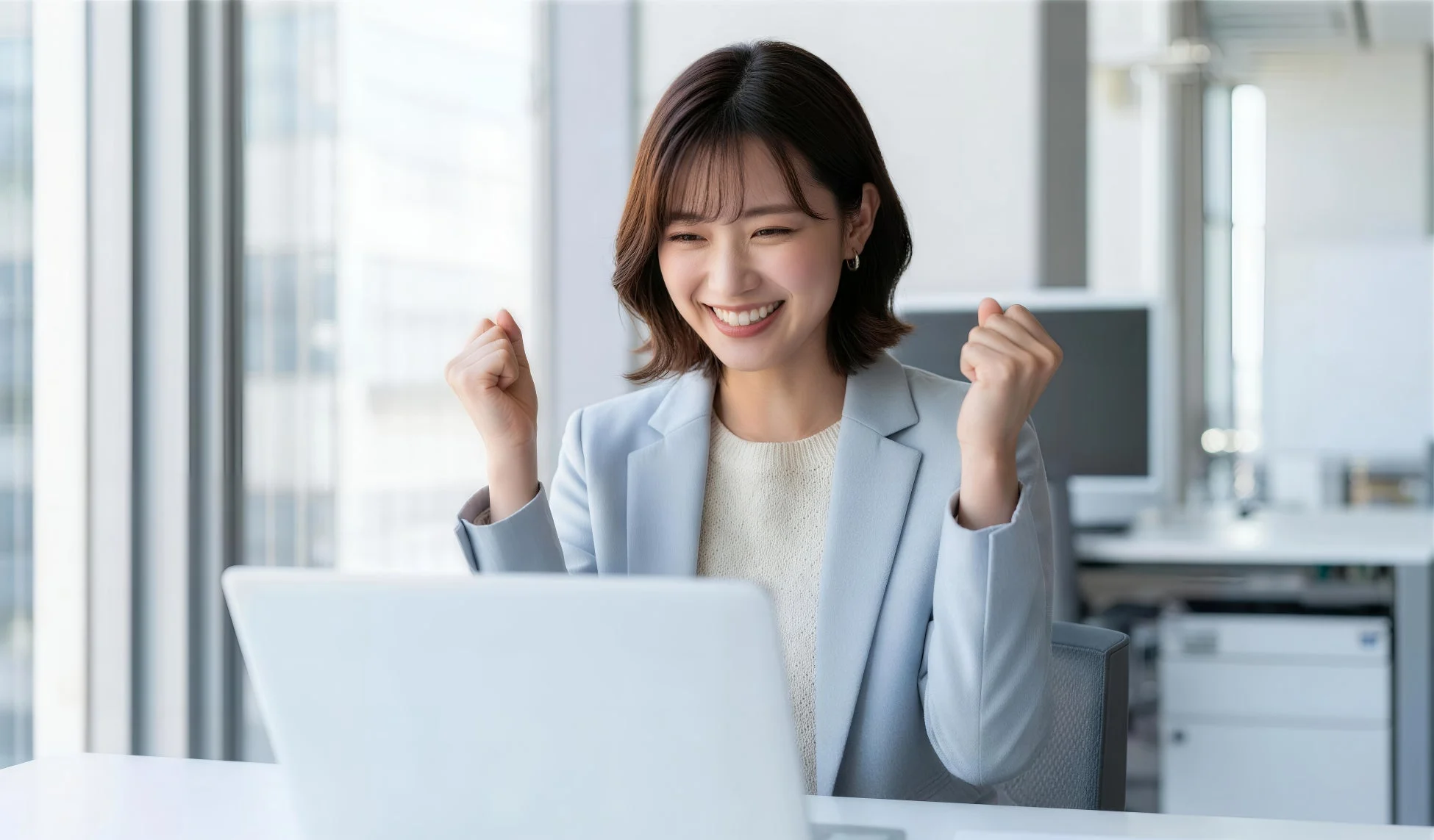 喜びの表情でPCを見る女性