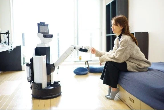 女性がロボットからマグカップを受け取る様子