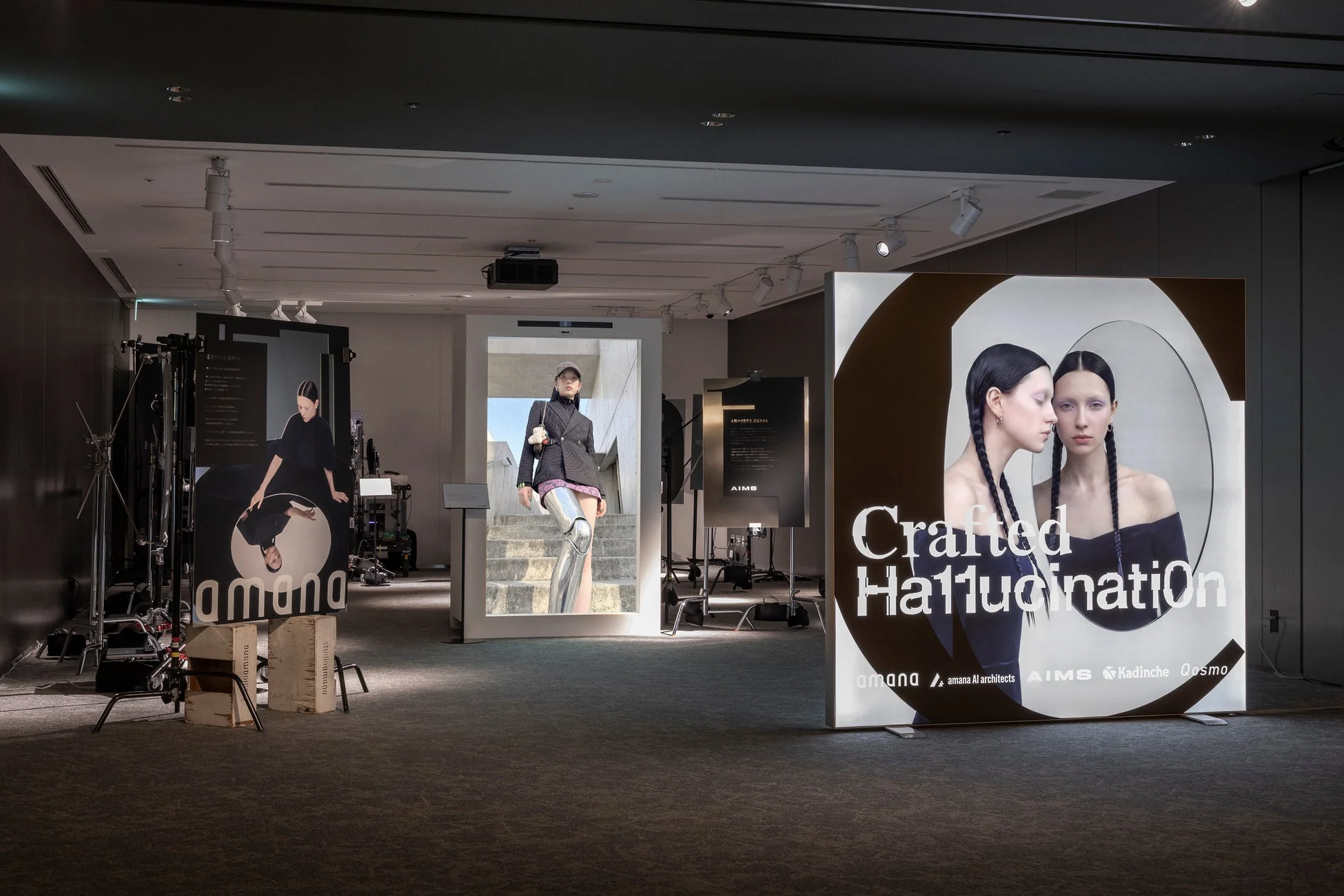 屋内展示空間で、複数の大型ディスプレイに現代アート作品が展示されています。